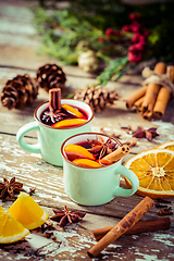 Image showing Mulled wine in rustic mugs with spices and citrus fruit