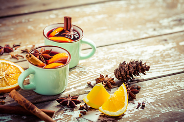 Image showing Mulled wine in rustic mugs with spices and citrus fruit