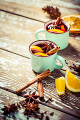 Image showing Mulled wine in rustic mugs with spices and citrus fruit