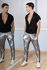Image showing Man in elegant sport suit posing in fitness gym. Young man in silver sport leggings