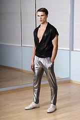 Image showing Man in elegant sport suit posing in fitness gym. Young man in silver sport leggings