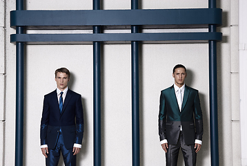 Image showing Two men in elegant suit on a wall background