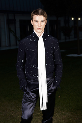 Image showing Male fashion, beauty concept. Portrait of young man with short wet hair wearing black suit, posing on street. Classic style.