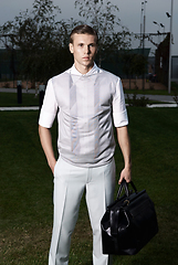 Image showing Portrait of an attractive young businessman in urban background wearing suit and necktie. Looking to the camera. Classic style. Studio shot