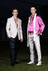 Image showing Fashion portrait of two young sexy handsome men models in casual cloth suit on green grass