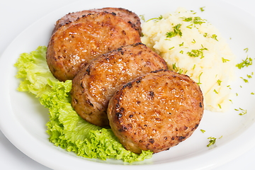 Image showing Three fried breaded cutlet with lettuce and mashed potatoes on white background