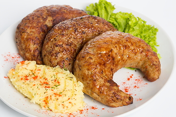 Image showing Three fried breaded cutlet with lettuce, mashed potatoes and pepper on white background