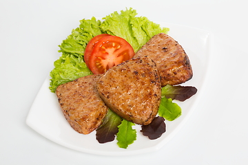Image showing Three fried breaded cutlet with lettuce and tomatoes on white background