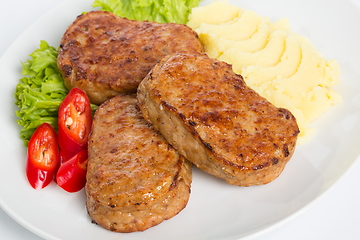 Image showing Three fried breaded cutlet with lettuce, mashed potatoes and pepper on white background