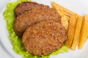 Image showing Three fried breaded cutlet with tomatoes and french fries on white background