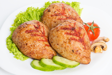 Image showing Three fried breaded cutlet with lettuce, tomatoes, cucumbers and mushrooms on white background