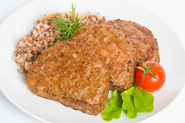 Image showing Three fried breaded cutlet with lettuce, tomatoes and buckwheat on white background