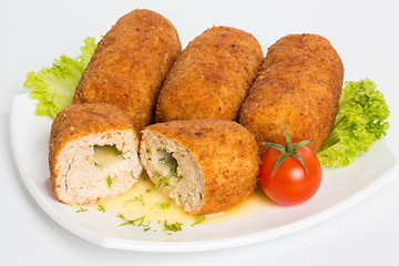 Image showing Four fried breaded cutlet with lettuce, tomatoes and cucumbers on white background