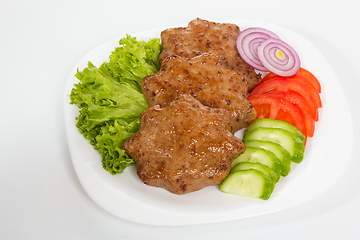 Image showing Three fried breaded cutlet with lettuce, tomatoes, cucumbers and onion on white background