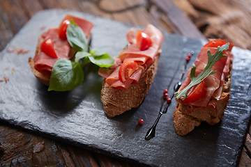 Image showing Bruschetta with hamon and sauce on black stone