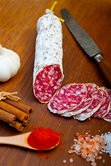 Image showing traditional Italian salame cured sausage sliced on a wood board