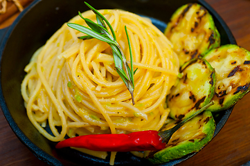 Image showing italian spaghetti pasta with zucchini sauce on iron skillet