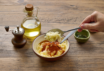 Image showing adding grated garlic to butter