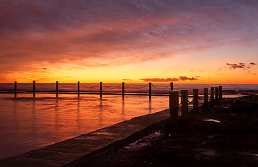 Image showing Red sky over tidal rock pool by the ocean