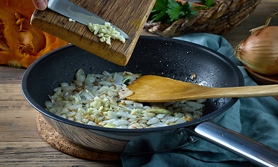 Image showing fresh chopped garlic is added to fried onions