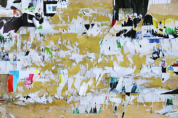 Image showing Dirty street yellow wall with old torn and peeling poster paper 