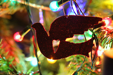 Image showing Red bird with heart, lights and decorations of cristmas tree