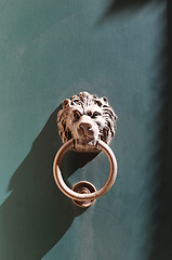 Image showing Doorknocker with head of lion on a green wooden door