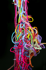 Image showing Multicolored tangled threads for needlework on black background