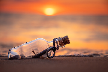 Image showing Message in the bottle against the Sun setting down