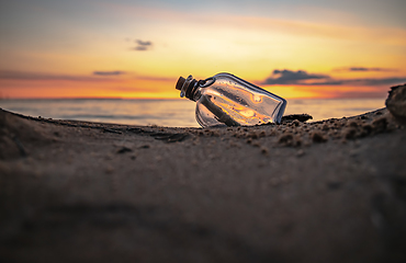 Image showing Message in the bottle against the Sun setting down