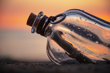 Image showing Message in the bottle against the Sun setting down