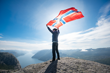 Image showing Woman with a waving flag of Norway on the background of nature