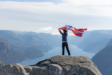 Image showing Woman with a waving flag of Norway on the background of nature