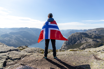 Image showing Woman with a waving flag of Norway on the background of nature