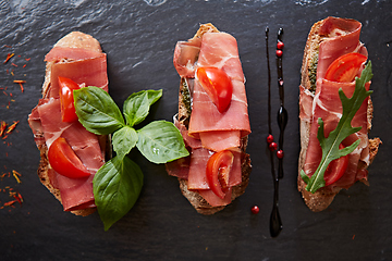 Image showing Bruschetta with hamon and sauce on black stone