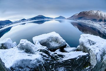 Image showing snow covered mountains and rocks my the sea