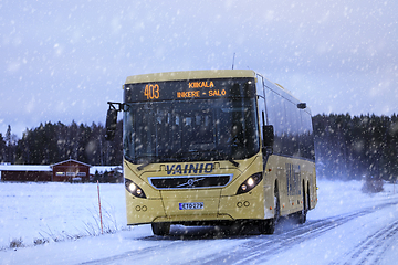 Image showing Yellow Volvo Bus Transports Passengers in Winter Snowfall