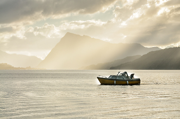 Image showing angler in a boat among mountains