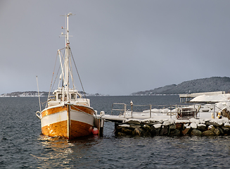 Image showing fishing boat at stone quay in winter