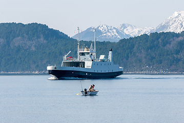 Image showing fishing in a small boat with a passing ferry