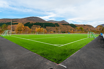 Image showing green soccer field with mountains and autumn colors