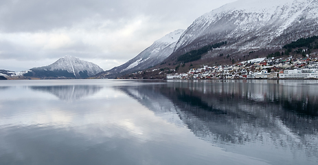 Image showing mountains reflected in water and small town