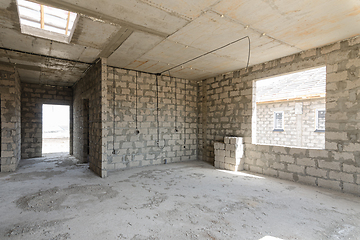 Image showing Construction of an individual residential building, view of a spacious room with a large window opening and a corridor leading to the front door