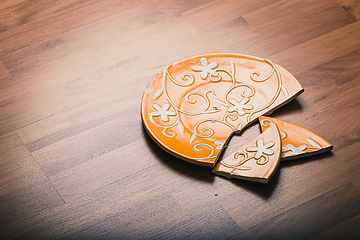 Image showing Broken ceramic plate on wooden floor