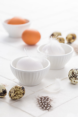 Image showing Different eggs with feathers for Easter on white background