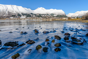 Image showing frozen sea with rocks sticking out of the ice with ørsta and ni