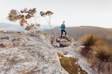 Image showing Female hiker looking out over views from high cliffs to valleys