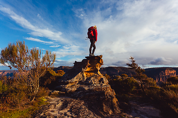 Image showing Woman hiker standing on top of rock precipice with grand views