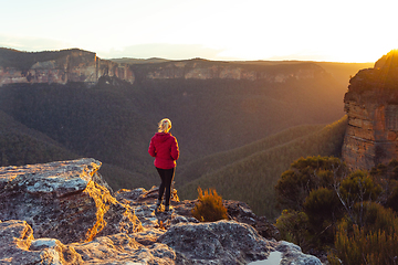 Image showing Sunlight streaming into valley and onto a cliff ledge hiker stan