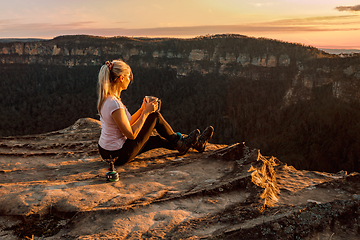 Image showing Girl is watching sunsets on cliff tops